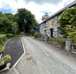 A house with a stone wall and garden at Delfryn, Newport
