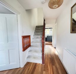 A hallway with a staircase and a door at Delfryn, Newport