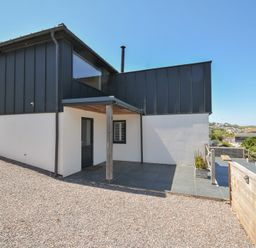 An outdoor area with a modern building and patio at Breakers View in Polzeath
