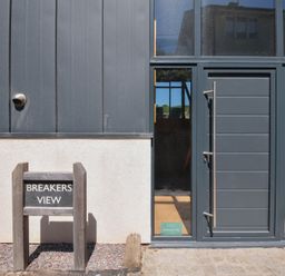 An exterior view of Breakers View with a sign at Polzeath