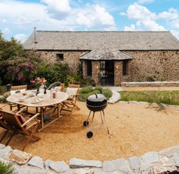 An outdoor dining area with a table and chairs at Hoppers Barn in Pancrasweek near Holsworthy