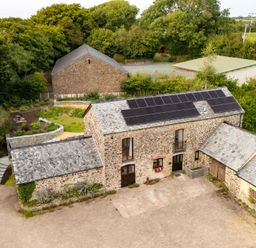 An outdoor view of a barn with solar panels at Hoppers Barn in Pancrasweek near Holsworthy