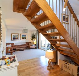 A living room with a staircase and sofa at Hillsview in Combe Martin