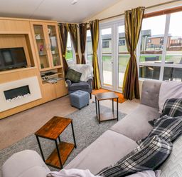 A living room with a TV and shelves at Reef Retreat in Little Haven