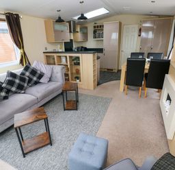 A living room with a sofa and dining area at Reef Retreat in Little Haven