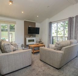 A living room with sofas and a television at Treetops, Beech Hill 13, Fallbarrow Park near Bowness-On-Windermere
