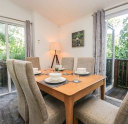 A dining room with a table set for dinner at Treetops, Beech Hill 13, Fallbarrow Park near Bowness-On-Windermere