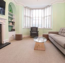 A living room with a sofa armchair coffee table and fireplace at Blencathra in Keswick