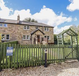 A house with a fence and garden at Apple Row Cottages in Lucker