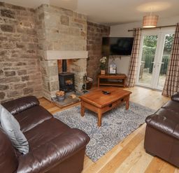 A living room with a fireplace and television at Crispin in Lucker