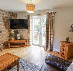 A living room with a television and sofa at Crispin in Lucker