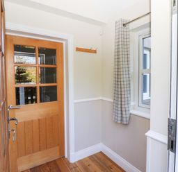 A hallway with a door and window at Pippin in Lucker