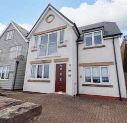 A house with multiple windows and a front door at Farne Cottage in Beadnell