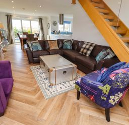 A living room with a sofa and coffee table at Farne Cottage in Beadnell