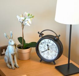 A table with a rabbit figurine a potted plant a clock and a lamp at The Pepper Pot in Warkworth