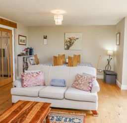 A living room with a sofa and dining table with chairs at The Mustard Pot in Acklington