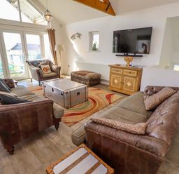 A living room with a coffee table and television at Spindrifter in Beadnell