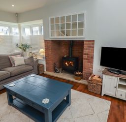 A living room with a coffee table and a television at The Beach Hut Beadnell