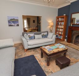 A living room with a sofa, coffee table, and bookcase at Number Seventeen Amble
