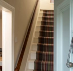 A hallway with a staircase and a decorative handle at Sandpiper (Alnmouth) in Alnmouth