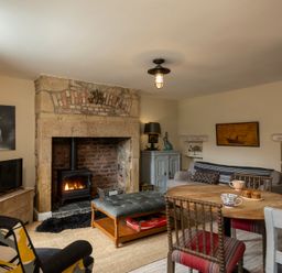 A living room with a fireplace and furniture at Sandpiper in Alnmouth