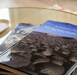 A close up of a table with two books and a heart shaped dish on it at Portside in Seahouses