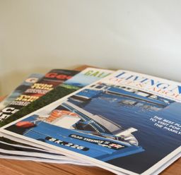 A stack of magazines on a wooden surface showing a boat on water on the top magazine at Rose Cottage Elsdon