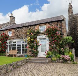 A house with flowers in the garden at Coble Cottage in Craster