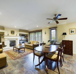A living room with sofas coffee table dining table and ceiling fan at Rokeby in Bamburgh