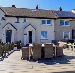 An outdoor seating area with table and chairs at Dunford Cottage in Bamburgh