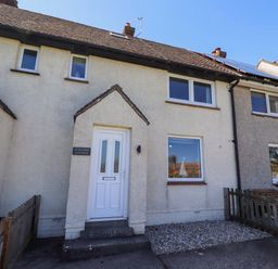 A cottage with a front door and windows at Dunford Cottage in Bamburgh