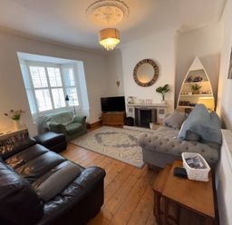 A living room with a sofa and television at Anchor Cottage (Seahouses)