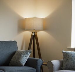 A living room with two armchairs a floor lamp and a window at Luna Tide in Seahouses