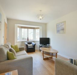 A living room with two sofas armchair coffee table and television at Coast View in Beadnell