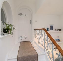 A staircase leading to a door in a hallway at Dell Point Beadnell