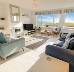 A living room with a television and sofas at Dell Point in Beadnell