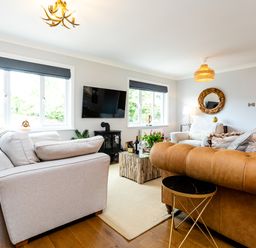A living room with sofas a television and a coffee table at Polished Pebble in Beadnell