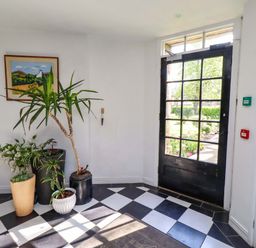 A hallway with plants and a door at Treetops, Alnwick