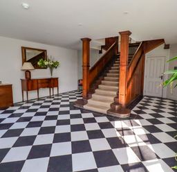 A hallway with stairs and a table at Treetops, Alnwick