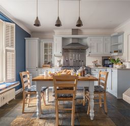 A kitchen with a dining table and chairs at Westhill House in Warkworth