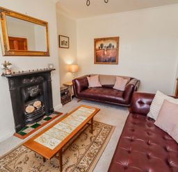 A living room with a fireplace and two sofas at Hardys House in Alnwick