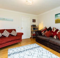 A living room with two sofas and a bookshelf at The Apartment in Bamburgh