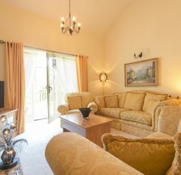 A living room with sofas a coffee table a television and a painting at Lavender Cottage Village Farm in Seahouses