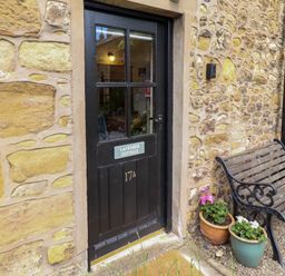 An entrance door with a nameplate and a bench at Lavender Cottage in Alnwick