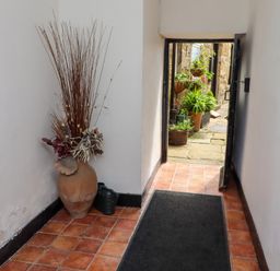 A hallway with a flower arrangement and a view of the garden at Lavender Cottage (Bailiffgate) Alnwick