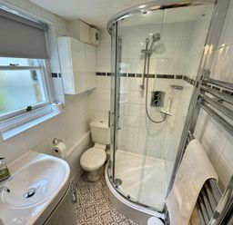 A bathroom with a shower enclosure toilet sink and towel rack at Dorothy Forster Court in Alnwick