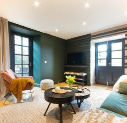 A living room with chairs coffee tables and double doors at The Bolthole in Eglingham