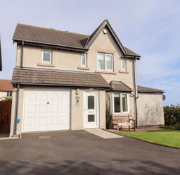 A house with a driveway and bench at Beach View in Seahouses