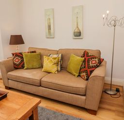 A living room with a sofa and cushions at Alnbank in Alnmouth