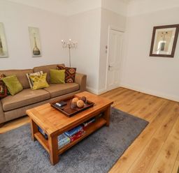 A living room with a sofa and coffee table at Alnbank in Alnmouth